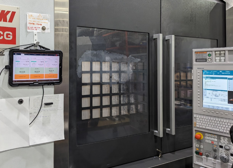 Tablette JITbase fixée à côté d'une machine CNC pour confirmer les tâches : tâches opérateur en temps masqué avec JITbase